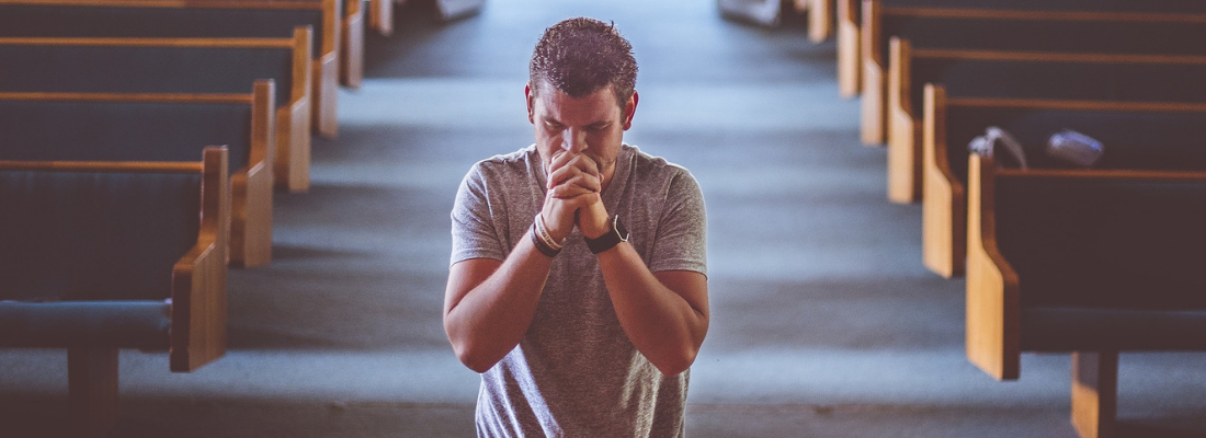 Man is Praying in the Church in His Knees