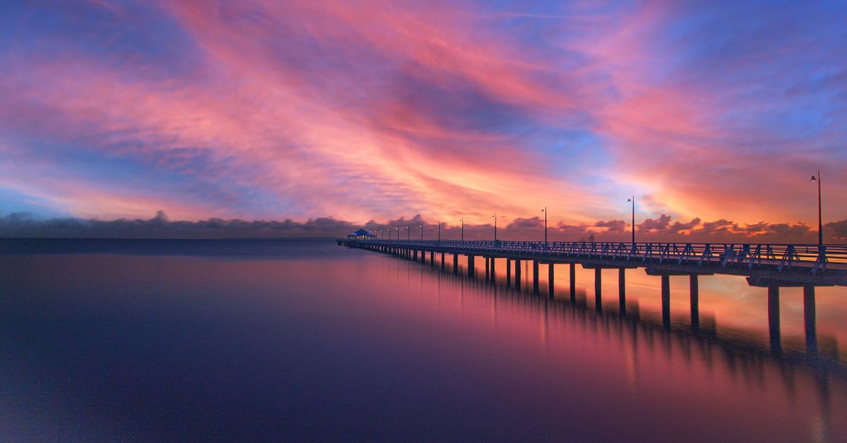 Be Strong and Courageous Trusting in God's Promises - Haly Ministries (on photo: a long pier and sun set)