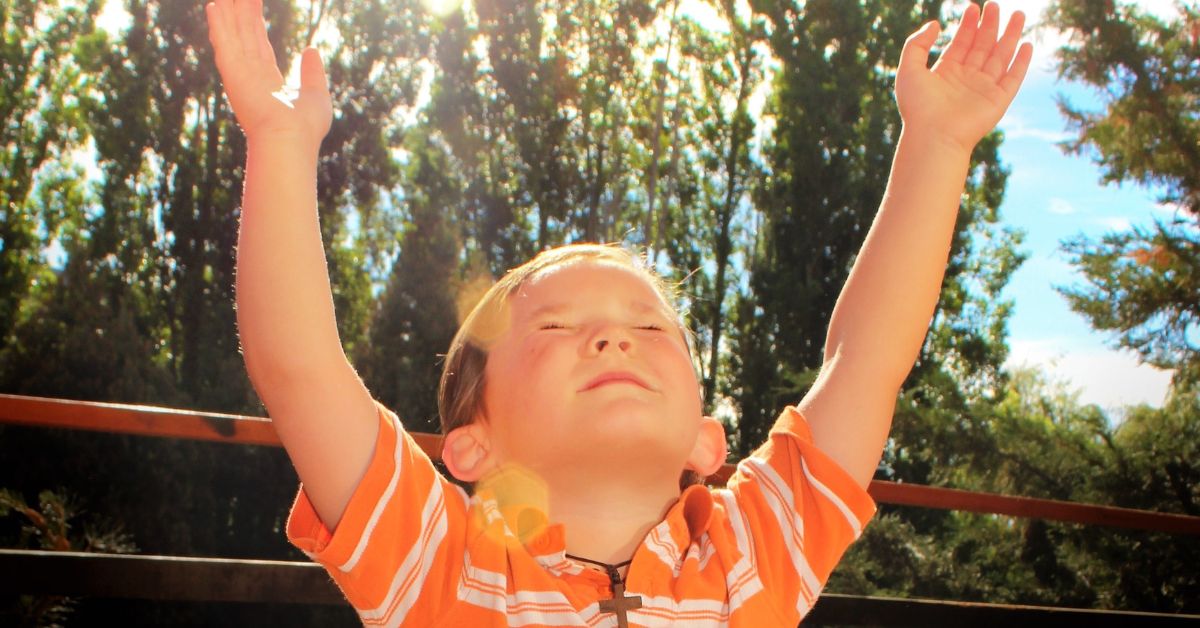 Benefits of Praising God - Haly Ministries (on photo: boy with lifted hands)