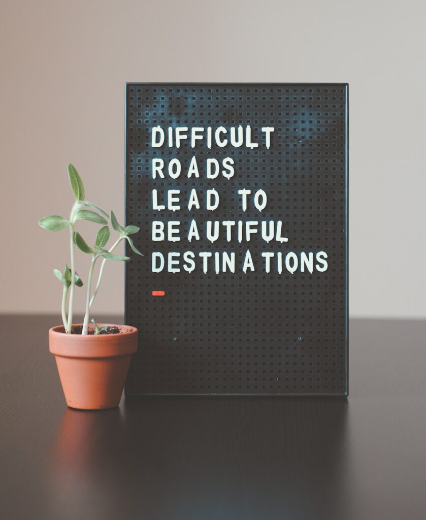Desk Canva with Words Difficult Roads Lead to Beautiful Destination
