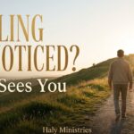 Man walking uphill alone through a field, representing a hidden season and the reminder that God sees you