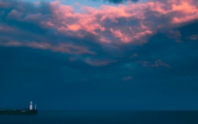 Finding Stillness in the Storm Trusting Through Chaos Prophetic Word - Haly Ministries (on photo: lighthouse by sea and red clouds)