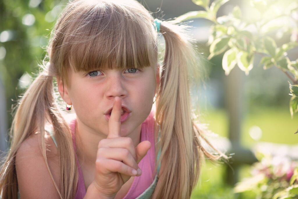 Girl Holds Finger to Nose Be Quiet