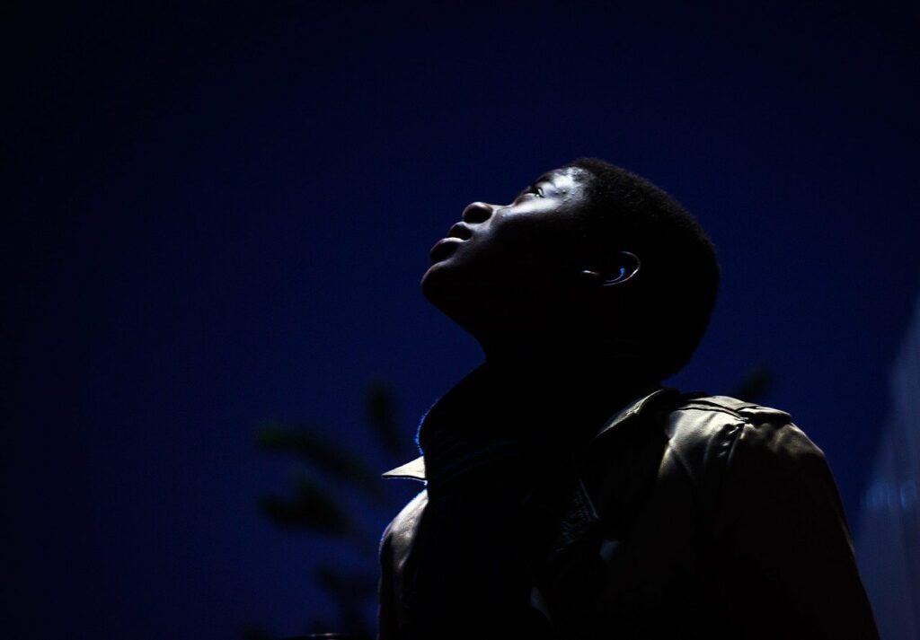 Man Looking Up with Light Shine on His Face