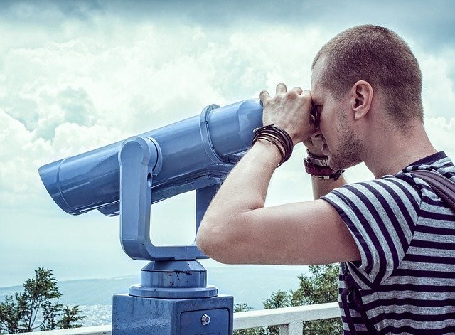 Man Looks Through Sightseeing Binocular