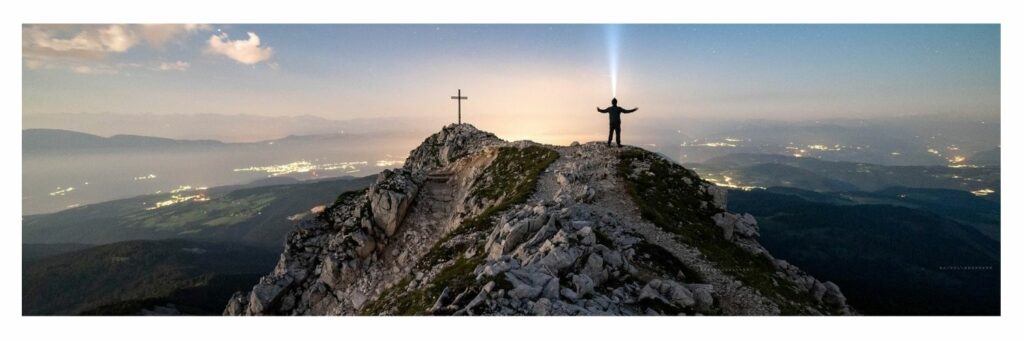 Man Standing on the Mountain Facing the Cross