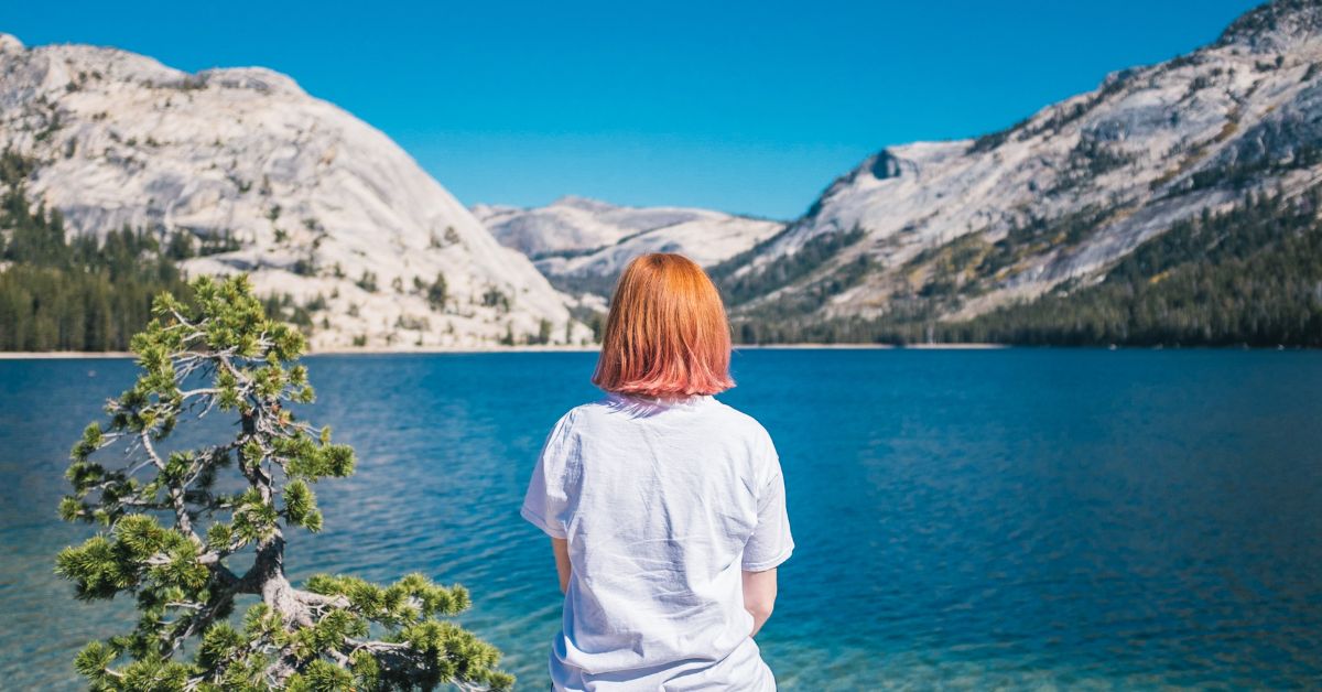 Peace Our True Strength - Haly Ministries (on photo: woman sitting facing lake and rocks)